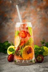 Refreshing mojito cocktail with strawberries and rum on the rustic background. Selective focus.