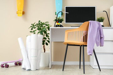 Interior of teenager's room with workplace, plants and skateboards