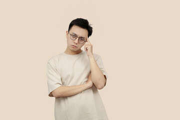 Thoughtful Young asian Man Contemplating Ideas While Standing Against a Neutral Background