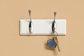 Rack with key from house on beige wall