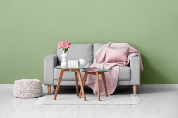 Calendar with date 17 March, flowers and magazines on glass tables near sofa in room
