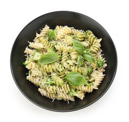 Black bowl of delicious fusilli pasta with broccoli and basil leaves on white background