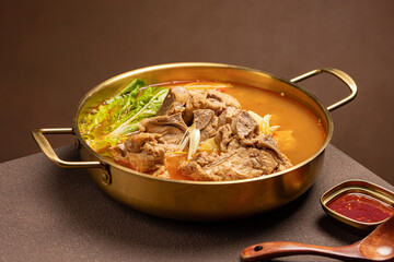 Traditional Korean pork back-bone stew (Gamjatang) served in a hot pot with perilla leaves, napa cabbage, potatoes, and rich savory broth. A spicy and hearty dish popular in Korean cuisine and comfort