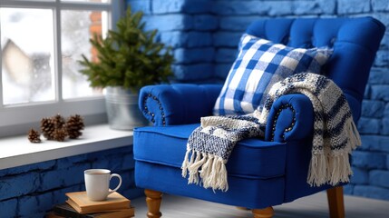 Blue chair with plaid blanket and coffee cup on wooden floor in bright natural light.