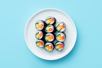 Japanese rolls on a ceramic plate on blue background close-up, top view.