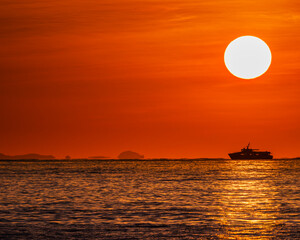 Boat sails under the hot Japanese setting sun