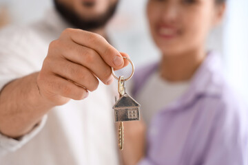 Young couple with key from their new house, closeup