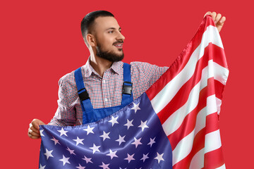 Male worker with USA flag on red background. Labor Day celebration