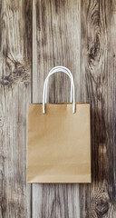 Top view of a realistic paper bag mockup placed on a rustic wooden surface, showcasing packaging design and texture details -