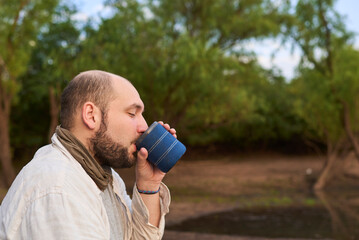 Hispanic man enjoys a cup of freshly brewed coffee in nature, early in the morning. Los Loros...