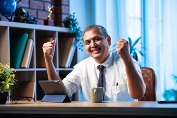 Indian corporate professional uses tablet for virtual call at office workplace