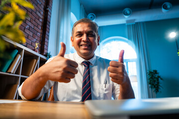 Confident Indian businessman on video call with client in stylish corporate office