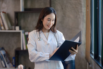 An Asian female professional, a successful doctor and practitioner, stands smiling in a white lab...