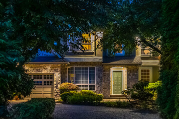 Two story stucco luxury house with nice Spring blossom landscape at night in Vancouver, Canada, North America. May 2025.