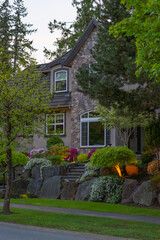 Two story stucco luxury house with nice Spring blossom landscape at night in Vancouver, Canada,...