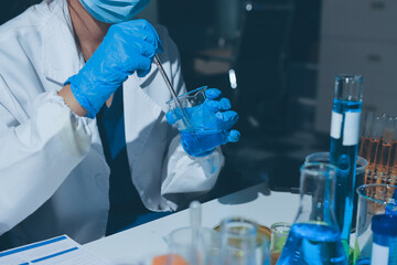 Scientist pipetting medical samples into microplate in laboratory