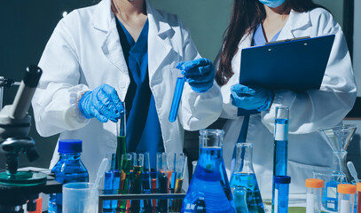 Scientist pipetting medical samples into microplate in laboratory