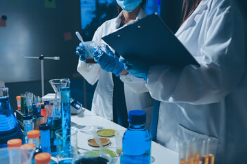 Scientist pipetting medical samples into microplate in laboratory