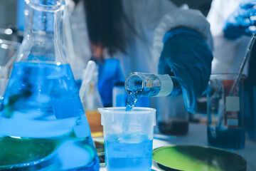 Scientist pipetting medical samples into microplate in laboratory