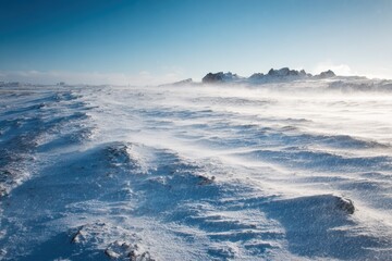 Fototapeta premium Stunning snowy winter scenery in Iceland featuring a chilly windy atmosphere and a lovely sky