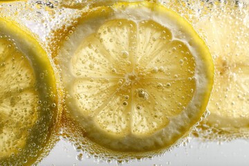 Macro close-up of lemon slices floating in clear water on white background, hyper-realistic citrus detail, commercial beverage content