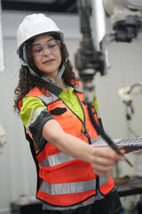 Hispanic engineer woman working on AI technology in robotics electronics engineering laboratory. University students' research project is programming robot machine with intelligent mechanical control