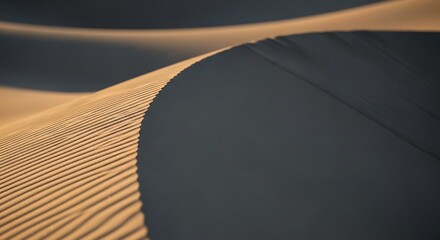Close-up of sand dunes with distinct ripples, showing light and shadow interplay on the textured surface.