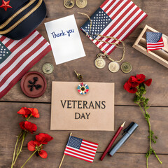 Fototapeta premium A flat lay of Veterans Day tribute items including a mini American flag, a poppy flower, a small thank-you card, and a military medal. Simple and respectful.