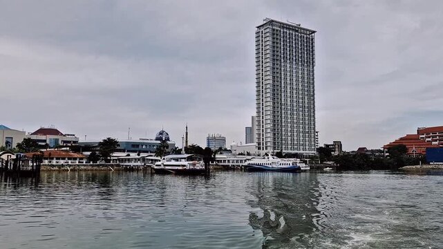 Tall and luxurious buildings around the port of Batam City, seen from a ship in the middle of the sea