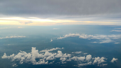 This image shows a beautiful view from above the clouds, taken from an airplane window. Fluffy...