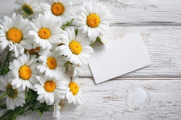 Fototapeta premium White daisies on a white wooden surface with a space for writing