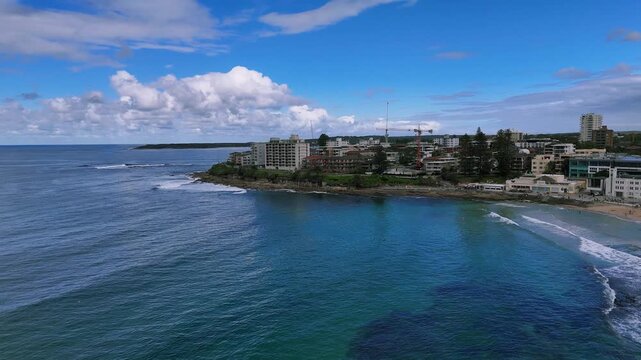Sydney, Australia: Drone flies over the surf at Cronulla Beach along The Esplanade, the walking trail and ending at the Shark's Island&ndash;a small Rock Islet outside the rocky coastline.
