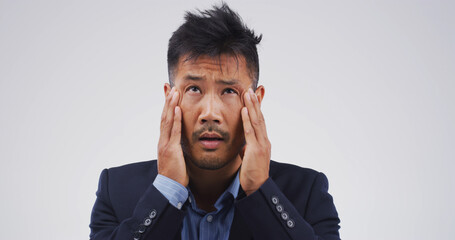Stress, headache and tired with business Asian man in studio for debt crisis, emergency or stock...