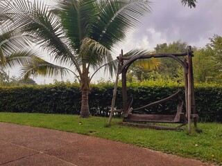 A wooden chair in a park in a state of disrepair