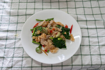 Sen Yai Pad Kee Mao Moo, a spicy Thai stir-fried noodle dish. Wide rice noodles are tossed with tender slices of pork, and an assortment of fresh vegetables including green long beans, baby eggplants.