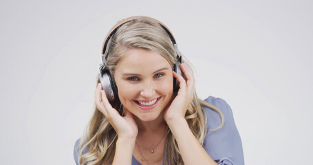 Fototapeta premium Woman, headphones and happy in studio portrait, digital streaming and album on white background. Person, smile and listen to music playlist, radio and audio subscription with mock up space in Germany