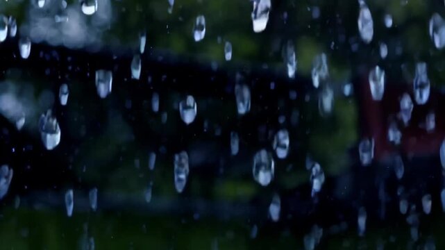 there is a red fire hydrant in the rain with a green background