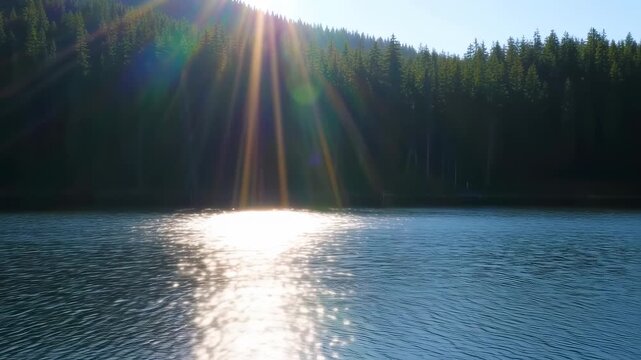 Sunlight beams over a still lake, reflecting on the water's surface, with a dense forest on the opposite shore
