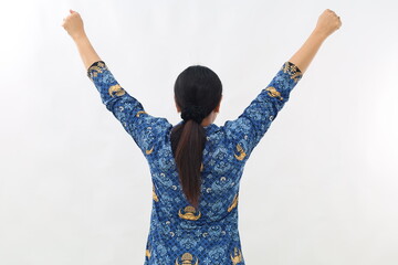Back view of enthusiastic Asian civil servant woman on white background holding arms in the air and...