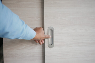 Hand opening a sliding door in modern interior design