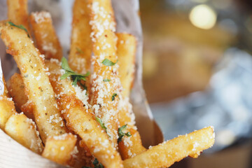 Crispy seasoned fries served in a wooden container indoors