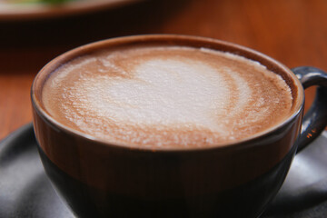 Latte art heart design in cozy cafe setting