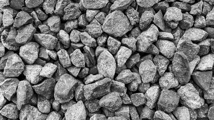 monochrome gravel stones in top view with rough and uneven surface. colored rock texture used for...