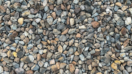 high resolution top view of natural gravel stones in various shapes and colors. ideal background for building, outdoor, or geology themes.