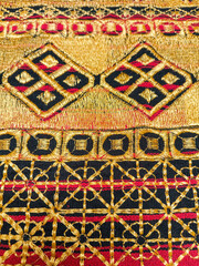 Kain tapis or Lampung tapis fabric with golden threads, geometric motifs, and traditional woven textures.
gold background or ethnic background concept
