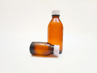 Two Amber glass bottles with aluminum caps on a white background, brown glass bottle for pharmaceuticals, syrups, essential oils, and cosmetics