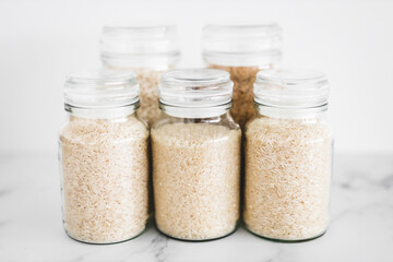 glass jar with rice of different varieties including jasmine basmati arborio sushi and brown rice,...