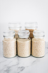 glass jar with rice of different varieties including jasmine basmati arborio sushi and brown rice, healthy pantry ingredients