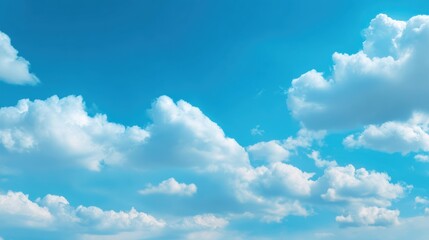 Fototapeta premium Bright blue sky filled with fluffy white clouds, creating a serene and peaceful atmosphere for any outdoor setting.
