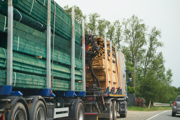 Vehicles transporting timber and wood planks on rural route